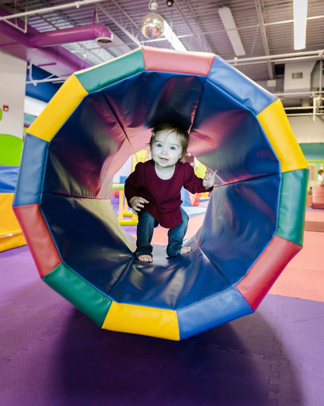 A little girl running through a matt tunnel, contact us for more indoor kids activities in Wethersfield, CT.