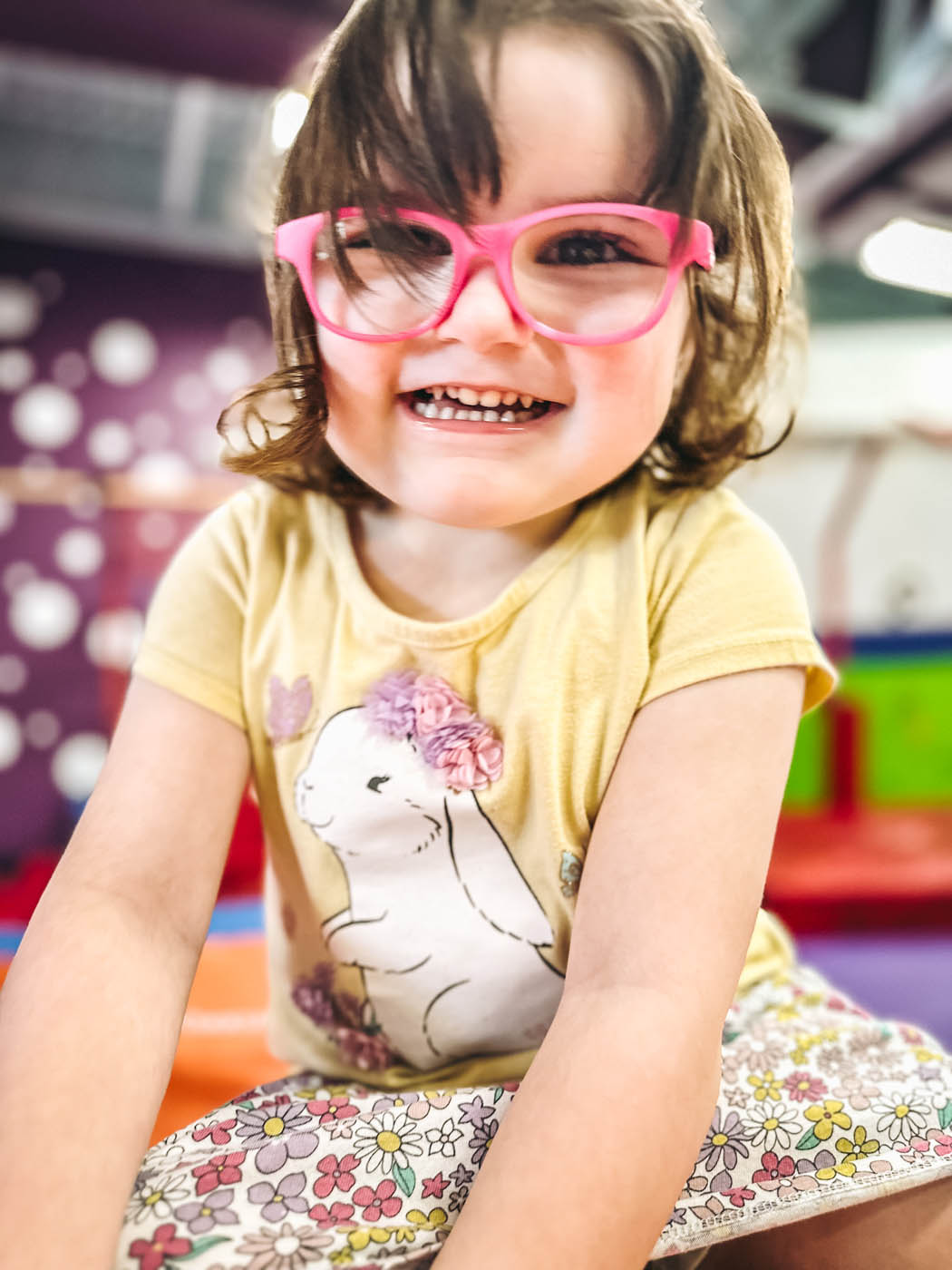 A little girl in cute pink glasses at Romp n' Roll charitable giving event.