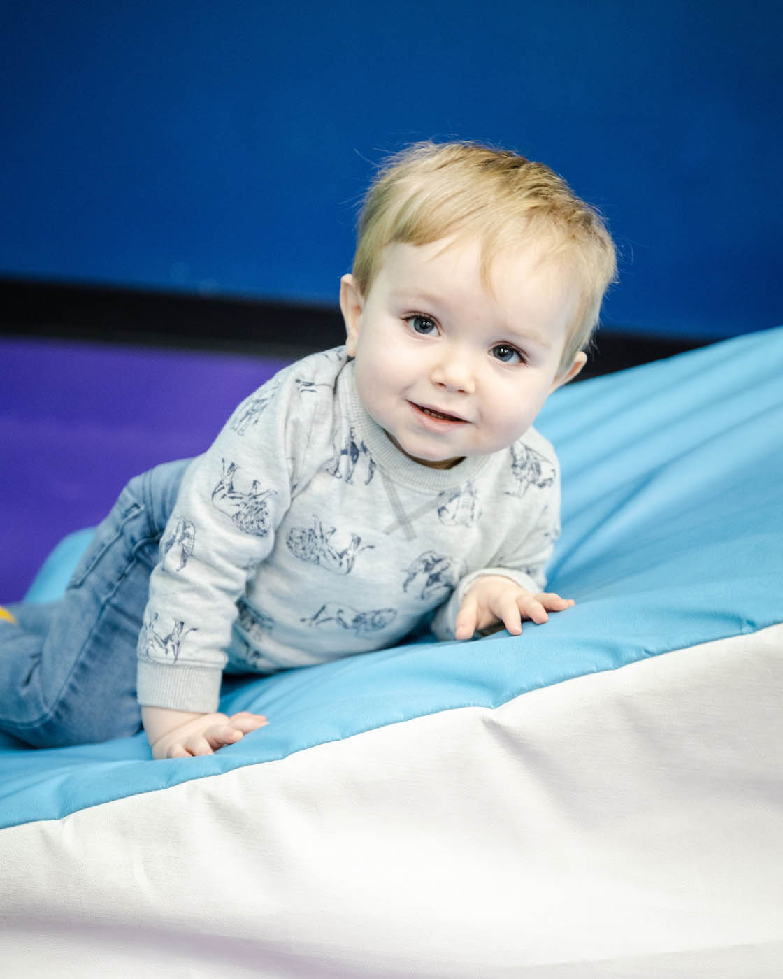 A baby boy taking advandage of Romp n' Roll Willow Grove's baby gym.