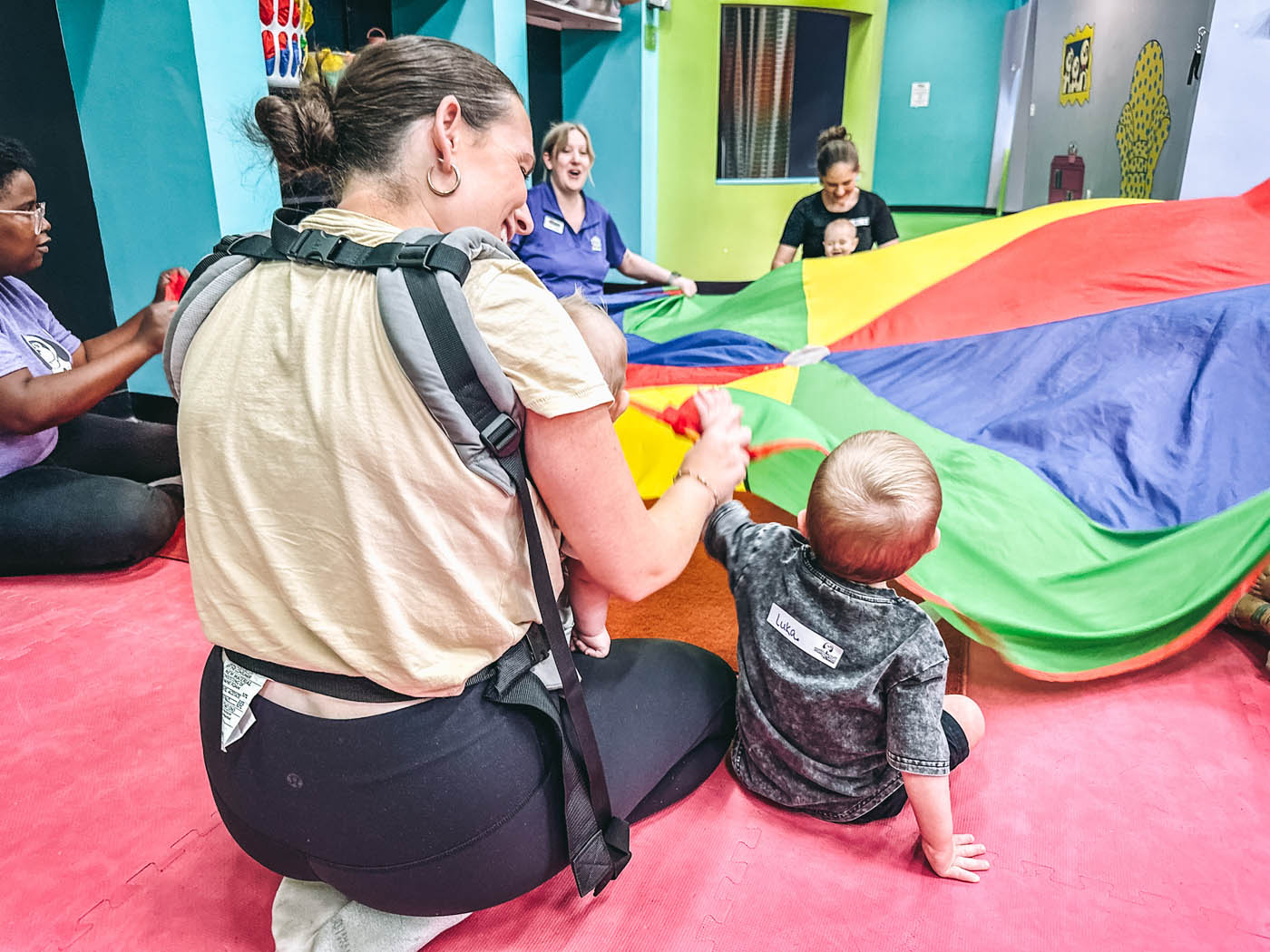 A group of small children with an instructor learning and playing together in a socialization class for kids in Wethersfield, CT.