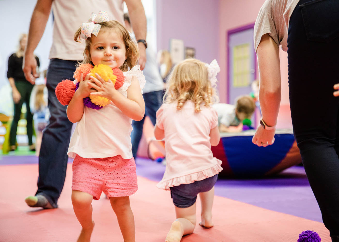 Kids playing with puffy balls in Romp n' Roll Northwest Charlotte's gym, contact us today for charitable giving options. 